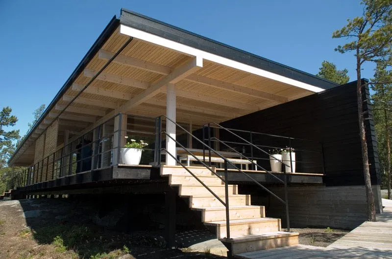 Dach pokrywa nie tylko sam domek, ale także dwa tarasy po lewej i prawej stronie