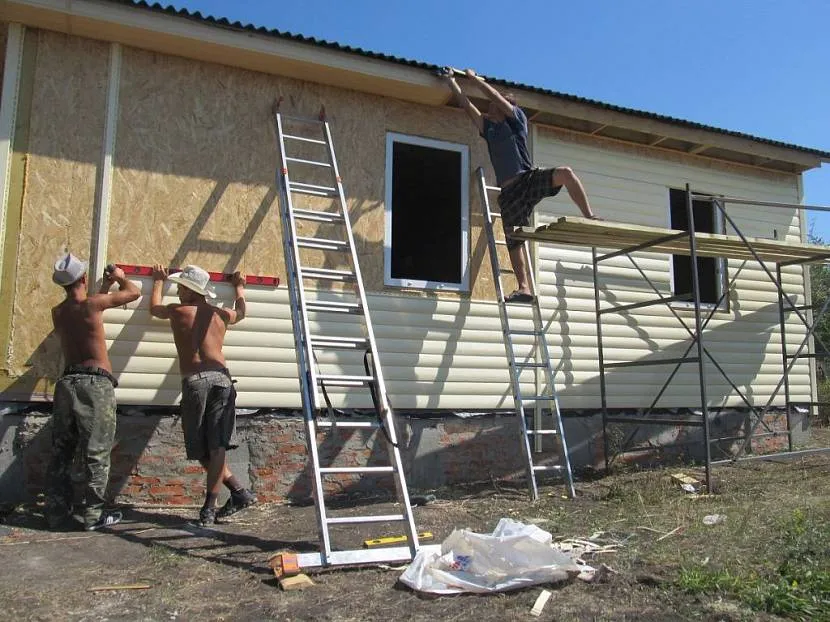 Зовнішнє оздоблення блок-хаусом світло-жовтого кольору одноповерхового заміського будинку