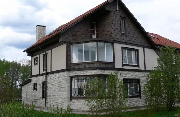 Zdjęcie domu z ceglaną bocznicą - stylowo wygląda połączenie z otynkowanymi ścianami w tej samej kolorystyce
