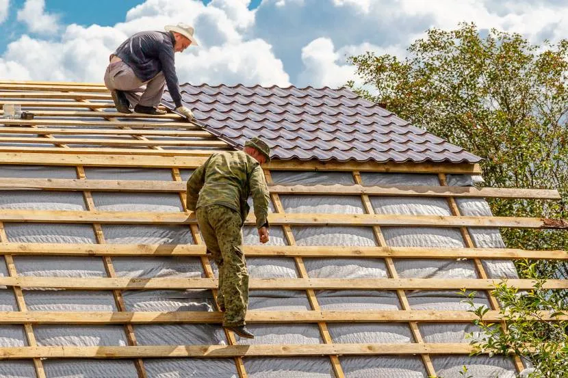 Процес накриття ламаного даху покрівельним матеріалом