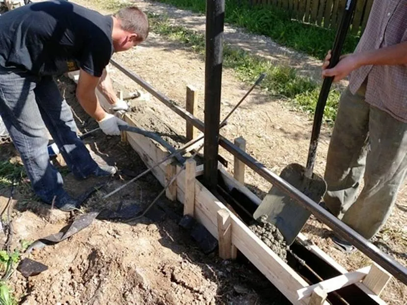 Заливка бетону для фундаменту паркану проводиться в заздалегідь заготовлену опалубку з армуванням.