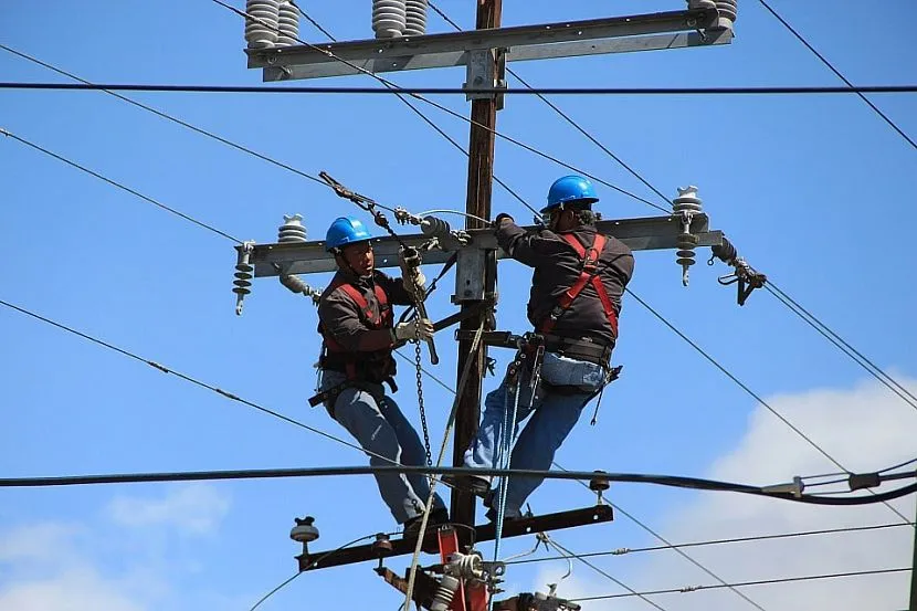 Elektrycy linii pracują na słupie elektrycznym