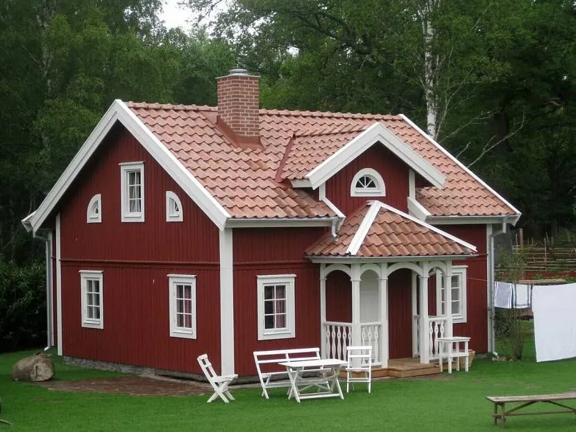 Oprawiony czerwony dom z masywnym dachem krytym dachówką