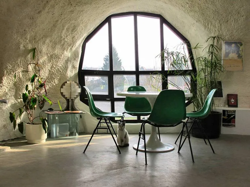 Pokój w stylu ekologicznym harmonijnie uzupełnia oryginalne okno w ciemnej ramie.