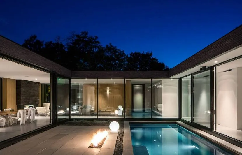 Zdjęcie domu z pięknie oświetlonym patio - jeśli chcesz, możesz pływać w basenie nawet późno w nocy