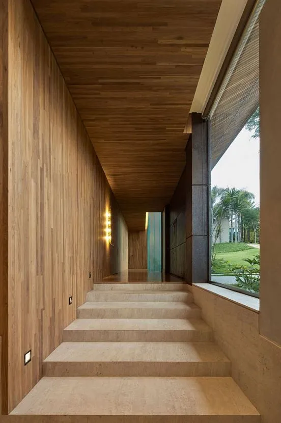 Główny korytarz łączący wszystkie poziomy domu wykończony jest drewnem poddanym obróbce cieplnej, ale jednocześnie pozostaje przestronny i jasny.