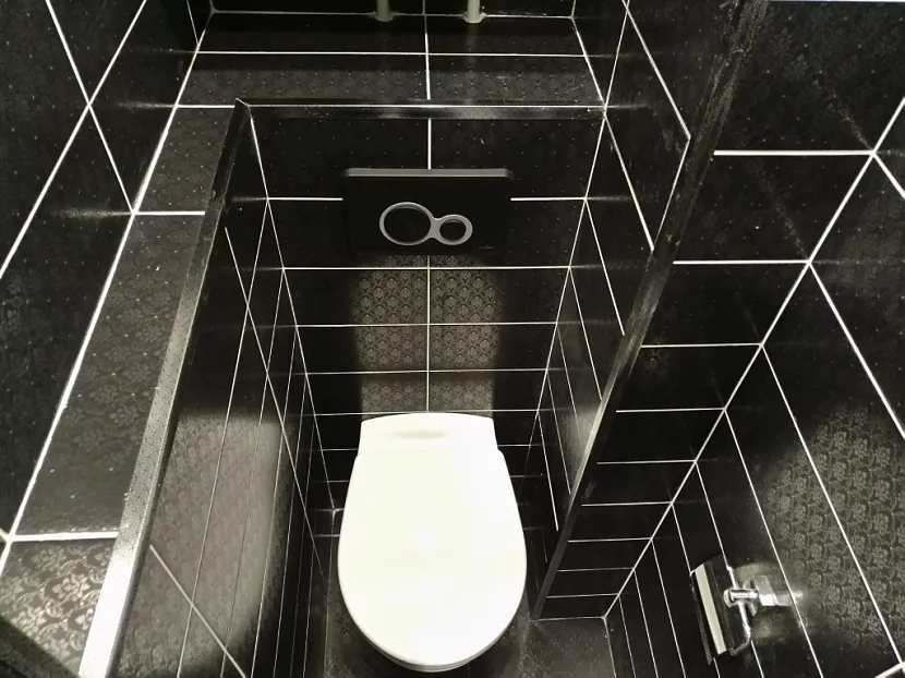 Czarne płytki z białą fugą w małej łazience