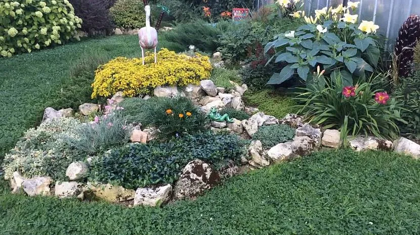 Figurka gipsowa pośrodku ogrodu skalnego