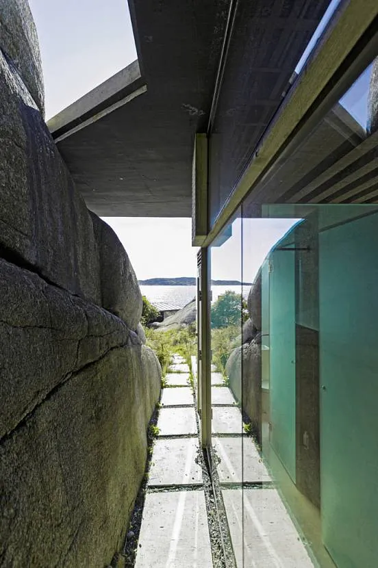 Wzdłuż domu można przejść ścieżką pozostawioną między szklaną ścianą a skałą