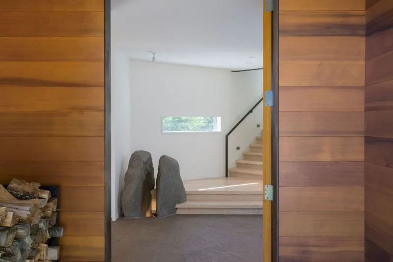 Z otwartych drzwi widoczne są drewniane schody, które prowadzą zwiedzającego na kolejne piętra domu.